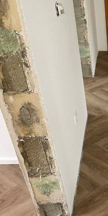 Geöffnete Wandlaibung im Altbau mit altem Putz, Mauerwerk und Ausbesserungen
